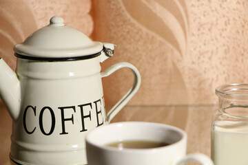  The concept of home comfort and warmth. On the table, a cup of coffee and a cake against a background of pink curtains.