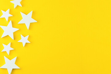 Zenithal view on a yellow background with white stars, representation of Christmas. Space for text or idea.