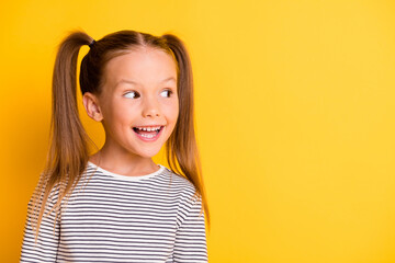 Portrait of young excited curious happy smiling girl child kid look in copyspace isolated on yellow...