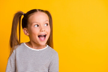 Portrait of happy excited amazed open mouth kid child girl look in copyspace isolated on yellow...