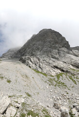 mountain with many stones and clouds behind