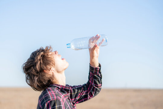 person in summer season feel thirsty and drink some water in desert