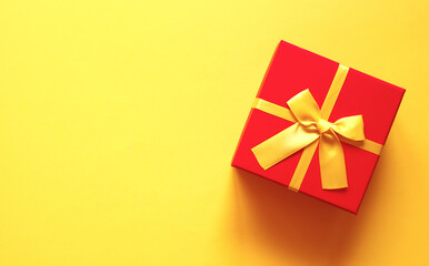 Obraz na płótnie Canvas bright red gift box on yellow background
