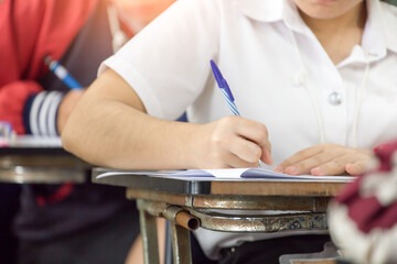 high school,university student study.hands holding pencil writing paper answer sheet.sitting lecture chair taking final exam attending in examination classroom.concept scholarship for education abroad
