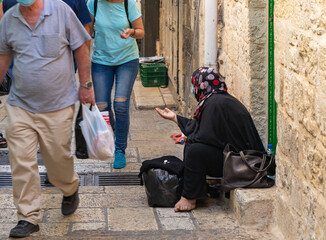 Elderly arab muslim woman sitting on the Beit HaBad street and begging for alms in the Muslim part...