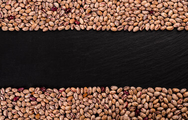 Coloren beans on black stone background.