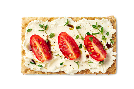 Bread crisps with cream cheese, tomato slices and herbs on white - Powered by Adobe