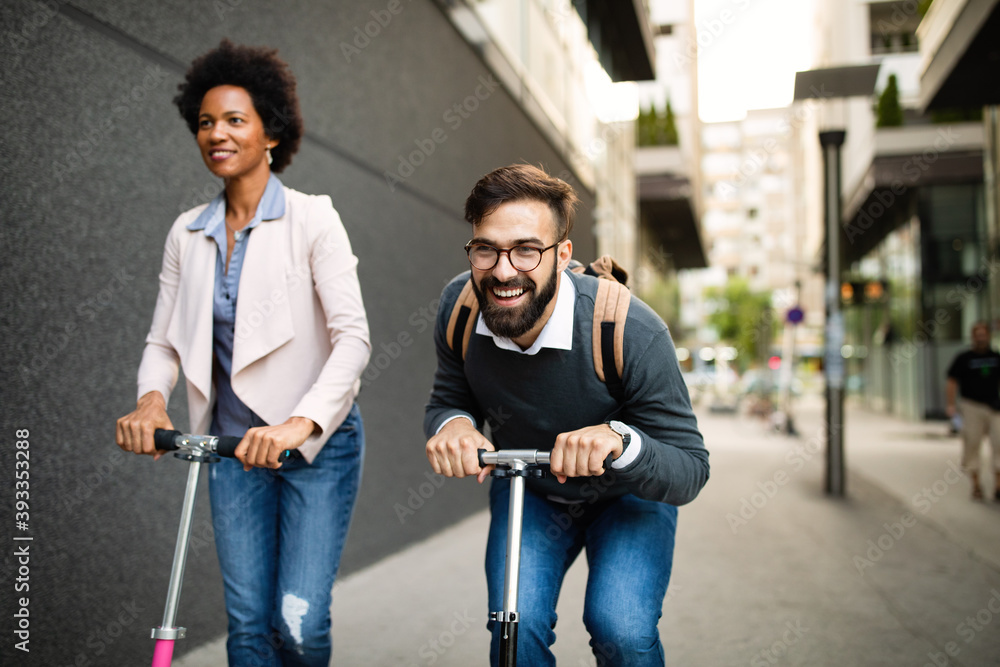 Wall mural Young couple on vacation having fun driving electric scooter through the city.