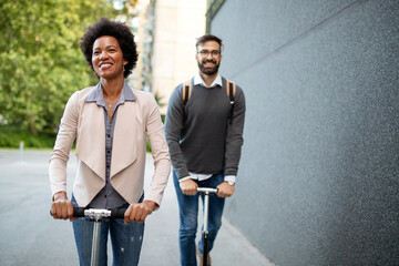 Happy young couple enjoying together while riding electric scooters on city street
