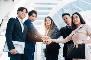Asian business people joining hands together.