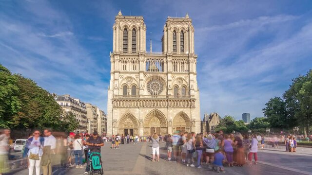 Front facade of cathedral of Notre Dame de Paris, with square full of people in front timelapse hyperlapse. Blue cloudy sky at summer day