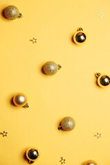 Christmas background with toys. Christmas gold ornaments on a yellow background. Flat layout, top view, copy space.