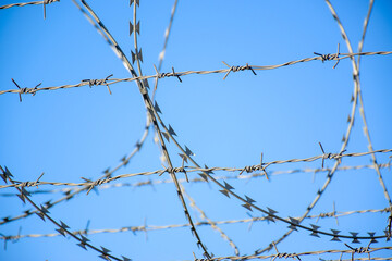 barbed wire against blue sky