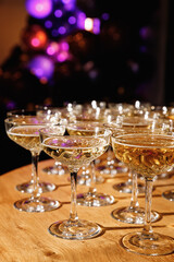 Glasses with Sparkling Wine. champagne glasses over Holiday Bokeh Blinking background. Celebration, party concept.
