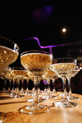Glasses with Sparkling Wine. champagne glasses over Holiday Bokeh Blinking background. Celebration, party concept.