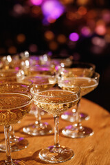 Glasses with Sparkling Wine. champagne glasses over Holiday Bokeh Blinking background. Celebration, party concept.