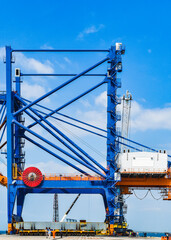 Transporting huge quay crane using self-propelled modular transporter. Moving huge quay crane from...