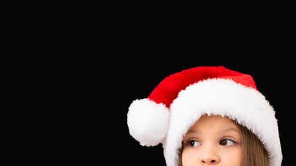 A child in a Christmas hat looks out.