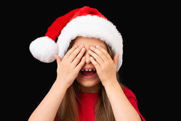 A little girl in a red t-shirt and hat covered her eyes with her hands.