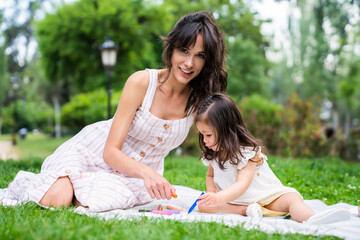 Young woman having rest with little girl in park