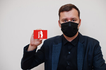 Man wear black formal and protect face mask, hold Warwickshire flag card isolated on white...
