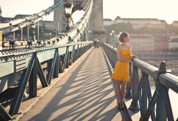 young woman walks on the chain bridge in budapest