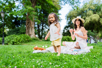 Young mom and little child playing in park