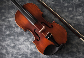 Violin front side put beside bow on background,