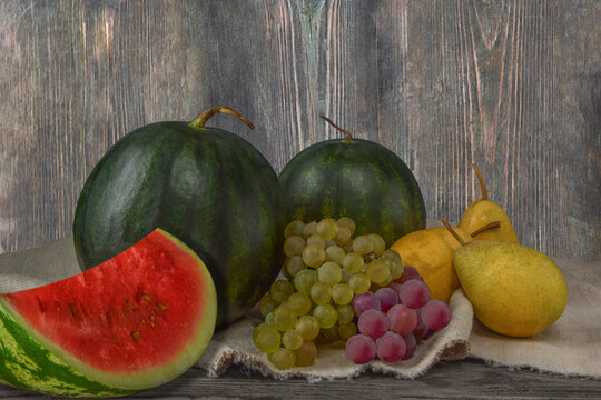 Still life of watermelon with grapes and pears.