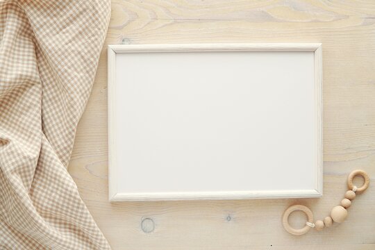 Nursery frame mockup, horizontal white wooden frame mock up for baby room art, pregnancy announcement, top view, flat lay.