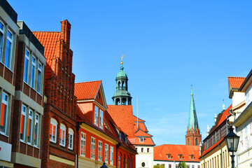 Streets of Luneburg city. The dome of town hall and spiel of Nikolaikirche (St. Nikolai church) in a background.