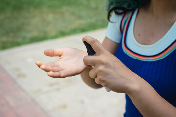 detalle de la mano usando un spray.