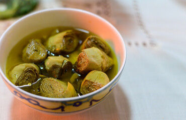 Italian food, pickled drilled artichokes hearts in olive oil