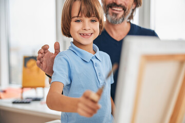 Excited gentleman and his son doing some painting