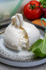 Eating of fresh handmade soft Italian cheese from Puglia, white balls of burrata or burratina cheese made from mozzarella and cream filling