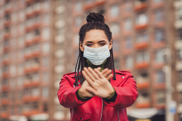 Photo of young african woman wear protection medical mask quarantine crossed hands stop coronavirus covid-19 street