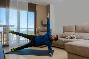 Latin man, doing a workout in his living room.