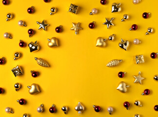 Christmas modern composition. Golden decorations  on yellow background. Flat lay, top view, copy space.