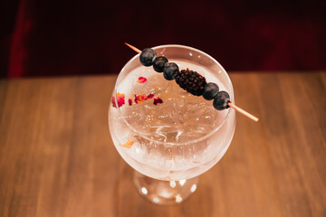 Cold vermouth cocktail with berries and ice cubes - obrazy, fototapety, plakaty