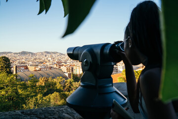 Fototapeta premium Woman looking through binoculars on viewpoint