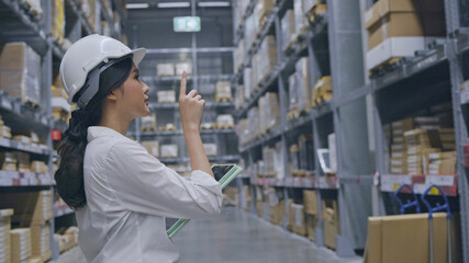 Warehouse worker or Asian woman Happy labor wear medical mask to prevent Coronavirus and PM2.5 dust. Wear hardhat for protection while working in the transportation industry. Concept key worker