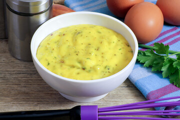 bol de mayonnaise aux herbes sur une table en bois