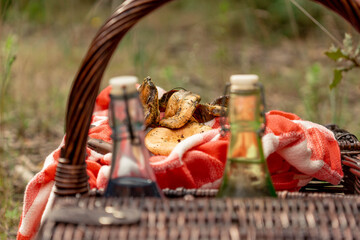 Freshly picked chanterelle mushrooms on a basket, seen through 2 glass bottles filled with water