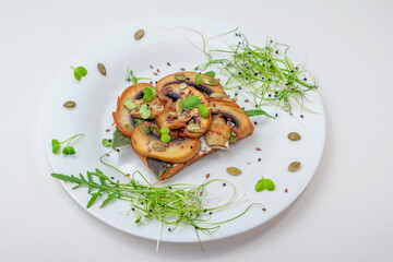 Sandwich with fried mushrooms, basil, pumpkin seeds and microgreens - radish and onion sprouts, served on white plate