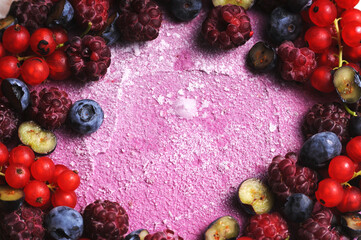 Festive cake, blueberry and blackberry sponge cake with cream cheese inside on a plate on a wooden table, horizontal view from above.Macro photo.