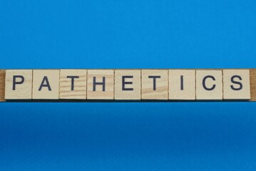 gray word pathetics in small square wooden letters with black font on a blue background