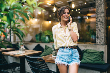 Smiling woman with smartphone in street