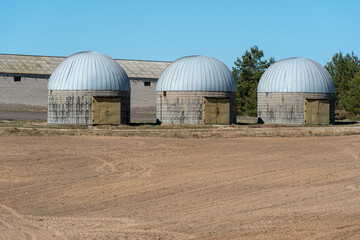 Obraz premium silver silos on agro manufacturing plant for processing drying cleaning and storage of agricultural products, flour, cereals and grain. Large iron barrels of grain. Granary elevator