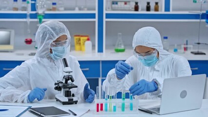 African american scientists analyzing sample near microscope and laptop - Powered by Adobe