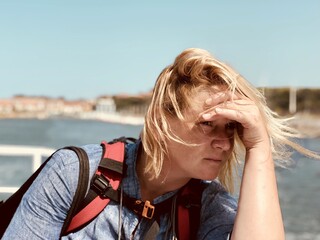 a woman looks into the distance. The wind blows woman's hair.